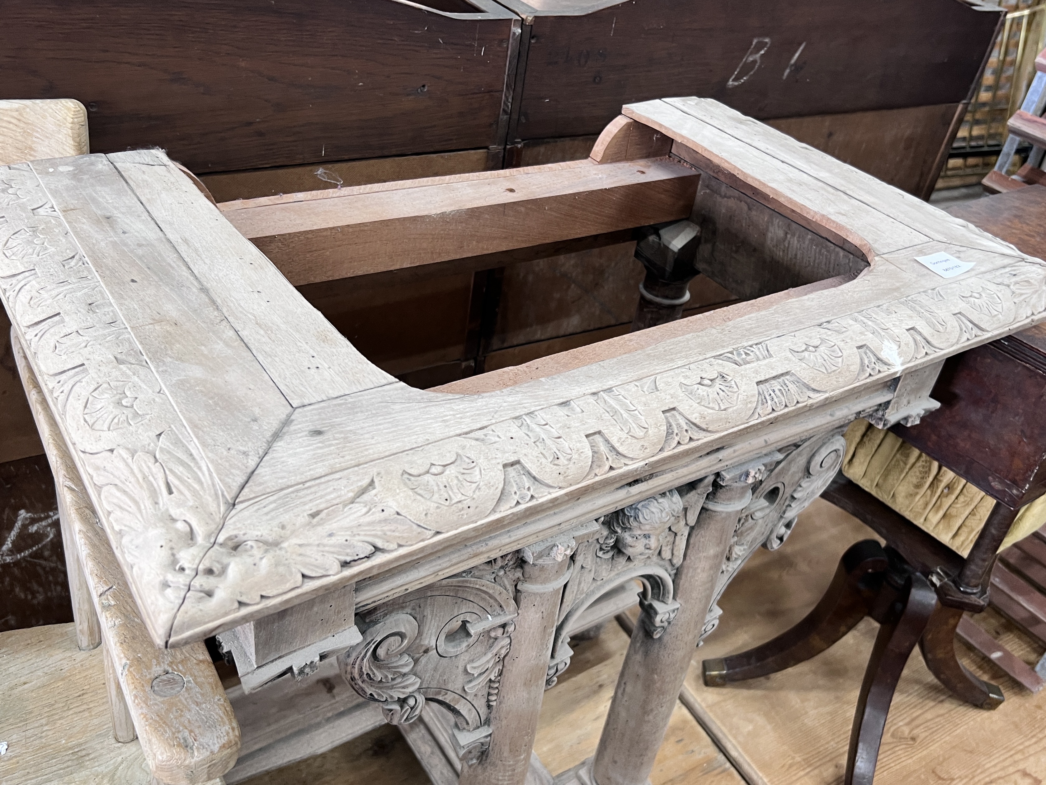 A limed carved pine table end, the top with a cut recess, width 78cm, depth 46cm, height 79cm